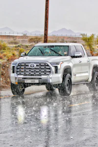 a white toyota tacoma truck driving in the rain