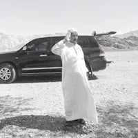 a man standing in front of a car in the desert