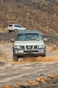 a nissan terrano driving through a muddy area